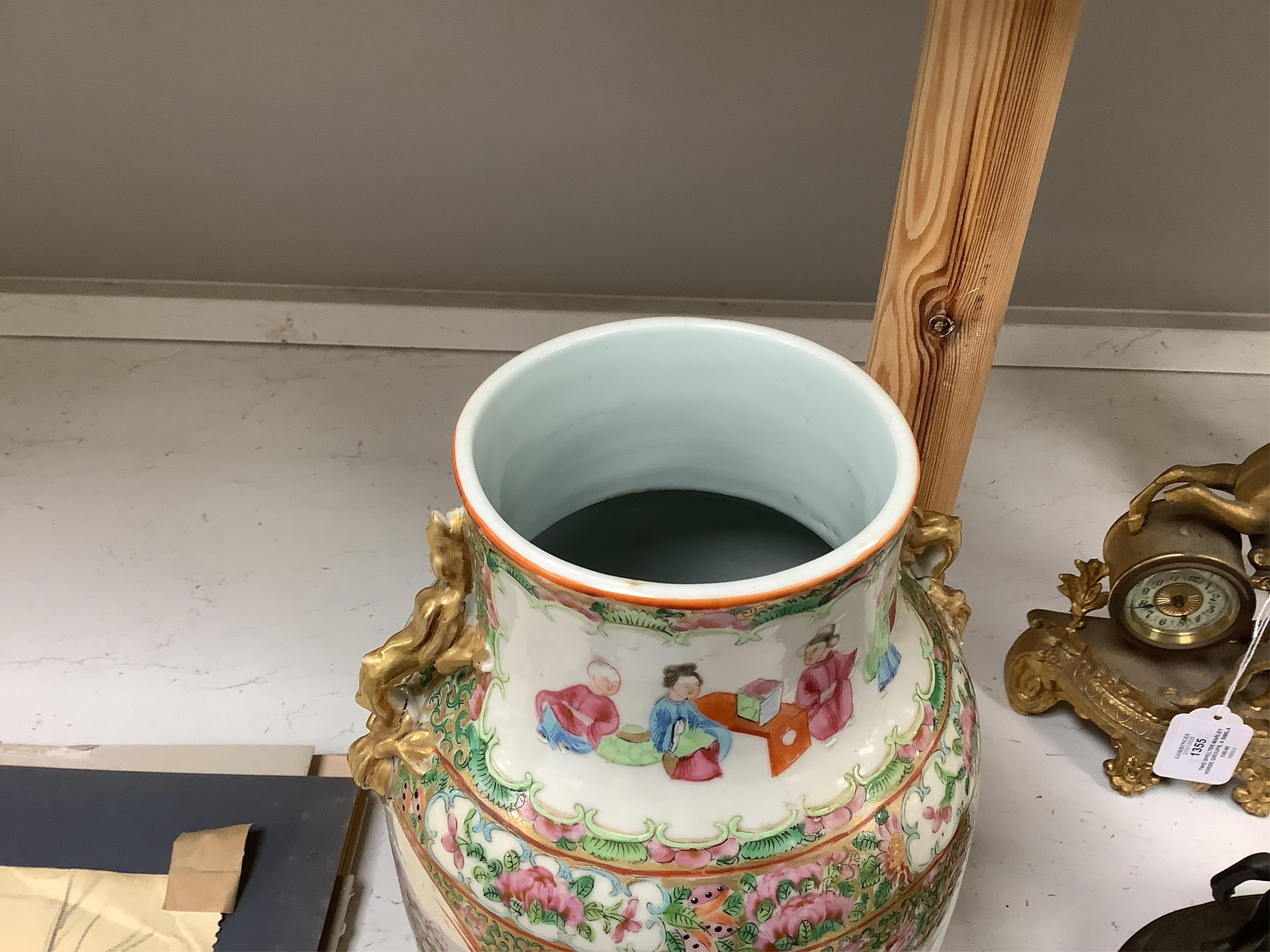 A Chinese famille rose vase and cover, late 19th century, together with a good carved hongmu ‘bats and shou’ stand, vase 36cm. Condition - crack to rim